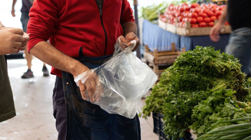 พ่อค้าถือถุงก๊อบแก๊บหูหิ้วในตลาดสด บรรจุภัณฑ์พลาสติกยอดนิยมสำหรับร้านค้าปลีกและร้านอาหาร
